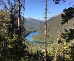 A view of Lightning Lake between the trees along the trail to Frosty Mountain