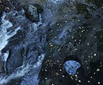 The view of the creek and the small waterfalls below the bridge