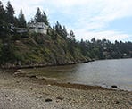 A rocky beach with houses along the cliff near Whytecliff Park in West Vancouver